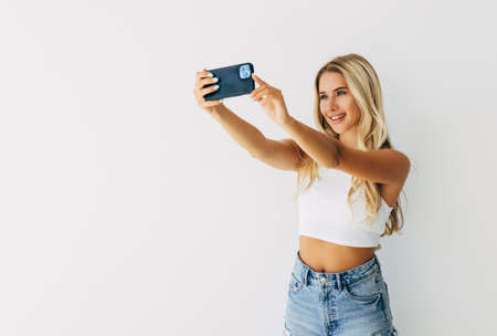 Young happy smile girl take selfie on white backgroundの写真素材