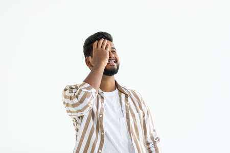 Young indian man wearing t-shirt standing over isolated white background suffering from headache...