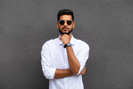 Charming young indian man in casual wear isolated on gray background