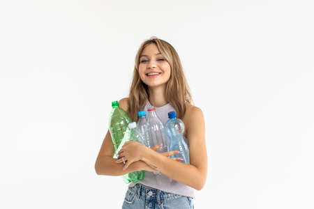 Young woman carrying a plastic container full with empty recyclable plastic. Recycling conceptの写真素材