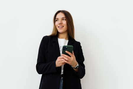 Young businesswoman use of the cellphone on white backgroundの写真素材