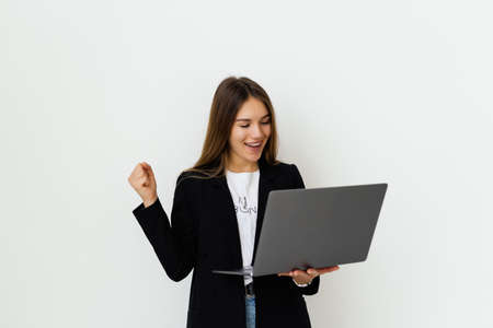 young beautiful modern woman having an laptop in hands, leaning on a white background