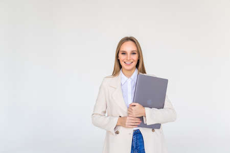 Portrait of a happy businesswoman holding laptop isolated over white background