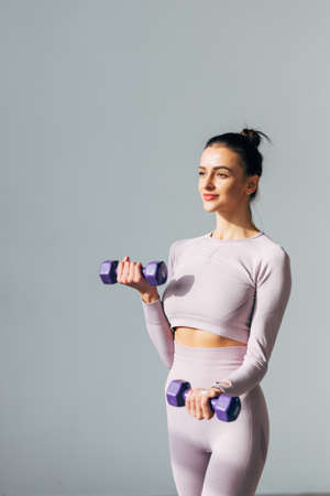 Woman exercising with dumbbells at studioの写真素材