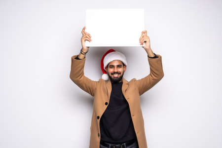 young man in a Santa Claus hat hold white board with space for text