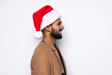 A young successful man with an Santa Claus hat on white backgroundの写真素材