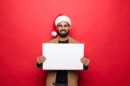 Asian man with Santa Claus hat standing on the red background.の写真素材