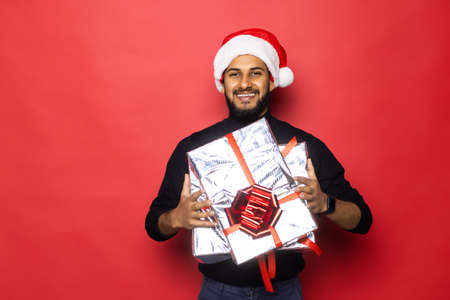 Santa christmas guy in red with background holding and opening golden gift present