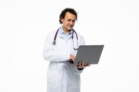 Happy young Doctor Holding Laptop Looking At Camera Isolated On White Background