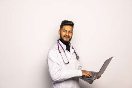 Young middle east doctor standing with Stethoscope and laptop isolated on white backgroundの写真素材