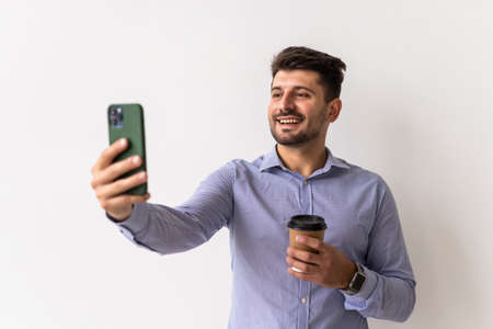 Portrait of man making video call from the phone isolated on white background