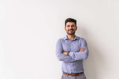 Portrait of young smiling caucasian man with crossed arms, wearing smart watch and casual denim shirt, isolated on whiteの写真素材