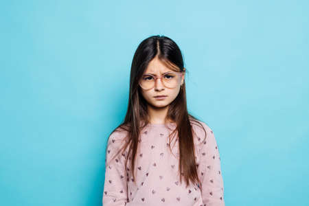 caucasian little girl wearing white T-shirt over blue background depressed and worry for distress, crying angry and afraid. Sad expression.の写真素材
