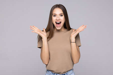 Surprised happy woman looking sideways in excitement, isolated on gray backgroundの写真素材