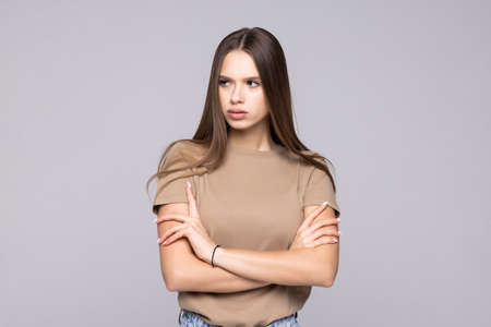 Confident serious woman with crossed hands on gray background.の写真素材
