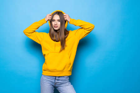 Happy woman smiling and looking at camera isolated over blue backgroundの写真素材