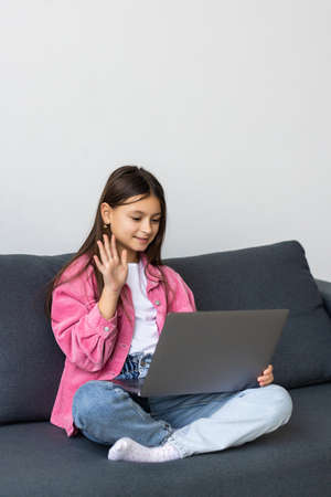 Little girl using video chat on laptop at home