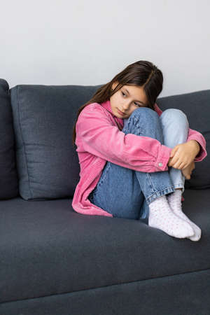 Little girl sitting on a couch and upset with something