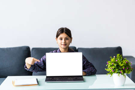 school, technology and internet concept - little student girl pointing at laptop pc at school