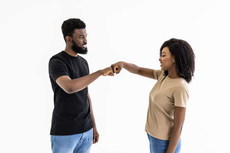 Young couple give hand to hand standing isolated on gray backgroundの写真素材