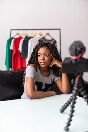African american female video blogger look at camera videoblogging at homeの写真素材