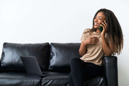 Portrait Of Young Girl Talking On phone Sitting on Couchの写真素材