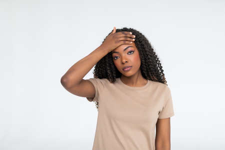 Upset young african woman touching forehead feeling headache hurt, sad ill black girl frustrated suffering from migraine fever, depressed about problem isolated on white backgroundの写真素材
