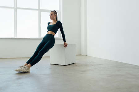 Photo of a young woman doing a box jump at the gym.の写真素材