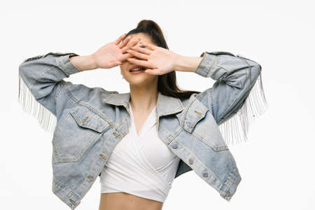 Attractive woman in jeans jacket with hands near face isolated on white background