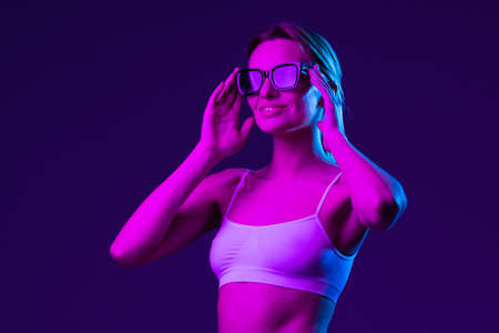 Fashion young woman wear stylish pink glasses looking at camera isolated on black studio background, horizontal banner for website design, portrait, copy spaceの写真素材