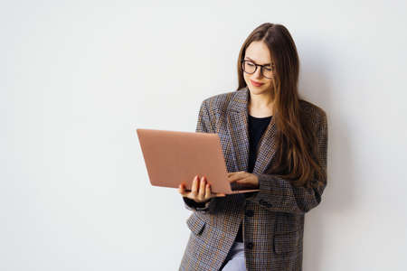 Confident businesswoman, office worker in white suit and glasses using laptop, help clientsの写真素材