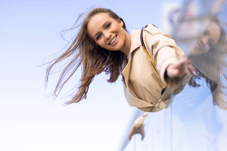 Elegant woman on the balcony looking at the streetの写真素材