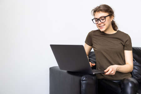 Woman using a laptop while relaxing on the couch