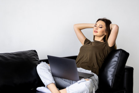 Happy girl chatting with friends in social network, spending lazy weekend, watching movie, shopping online, writing emailの写真素材