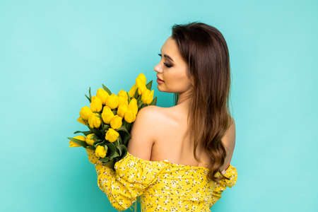 Happy girl with yellow tulips. green backgroundの写真素材