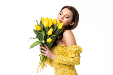 Portrait of a young woman with a bouquet of red tulips.の写真素材