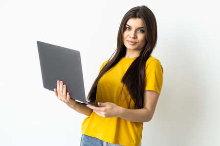 Portrait of young woman in casual outfit with laptop on white backgroundの写真素材