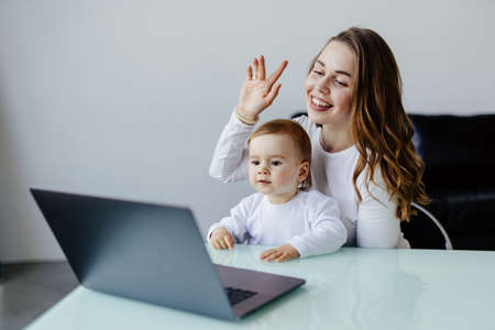 medicine, technology and healthcare concept - happy mother with baby son having video chat with...