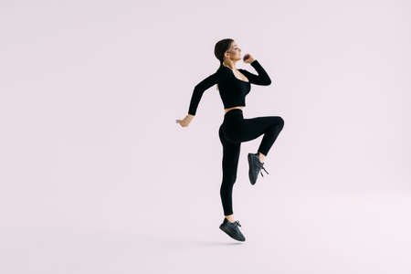 Full length portrait of a smiling fitness woman s working out isolated over white background
