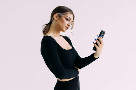 Portrait of a fitness woman using mobile phone isolated over white background