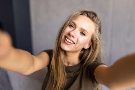 Picture of young amazing happy emotional pretty lady lies on sofa indoors. Looking camera make...