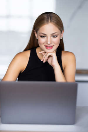 Pretty woman connected on internet with laptop at homeの写真素材