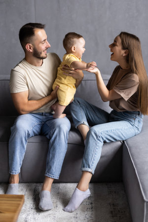 Portrait of happy family sitting together on sofa in living roomの写真素材