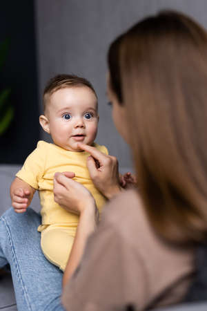 happy loving family. mother playing with her baby in the sofa
