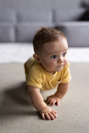 Little pretty son crawling on the floor at homeの写真素材