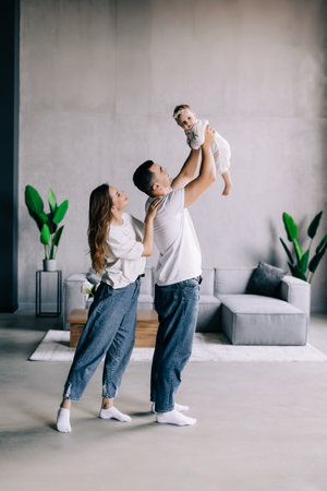 Happy family mother, father, child baby daughter at home on the sofa playing and laughing