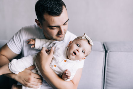 Parenthood and people concept - happy father with little baby daughter at home