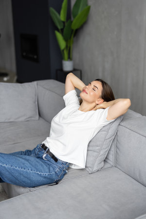 Young woman relaxing on couch in living roomの写真素材
