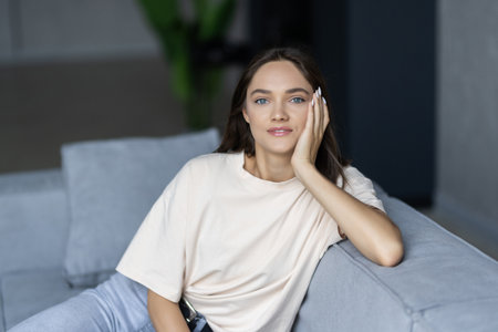Young woman lying at home living room couchの写真素材