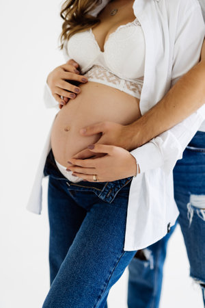 Young pregnant woman with husband isolated on whiteの写真素材